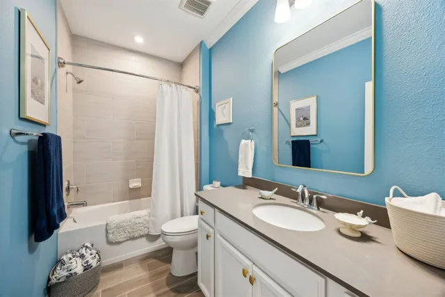 a bathroom with a granite countertop sink toilet and shower