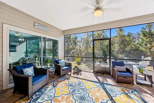 a living room with furniture tv and a floor to ceiling window