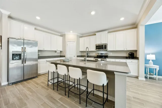 a kitchen with kitchen island granite countertop a counter space a sink appliances and cabinets