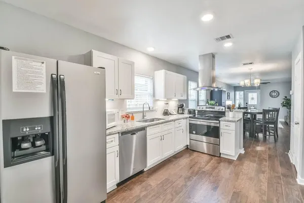 a kitchen with white cabinets and stainless steel appliances