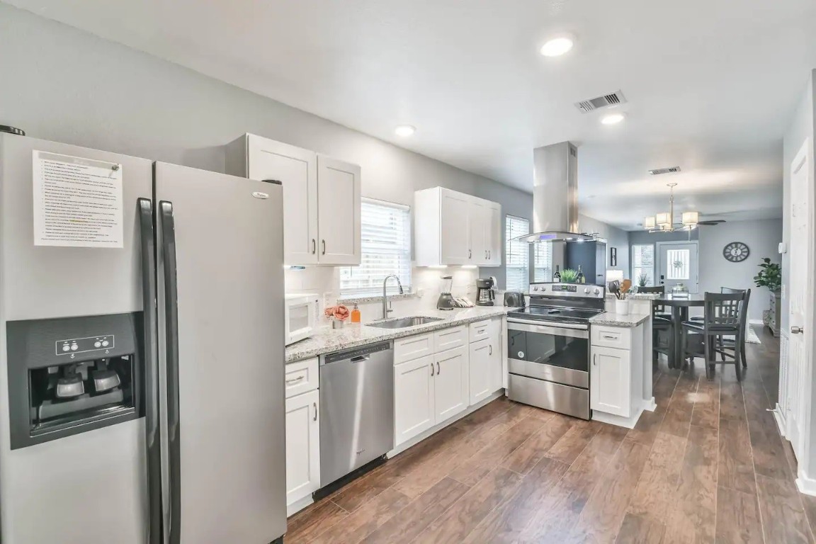 1212 Hamblen Street Houston, TX 77009 - Photo 4 of 13 a kitchen with white cabinets and stainless steel appliances