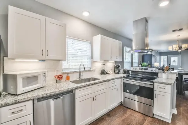 a kitchen with granite countertop white cabinets and white appliances