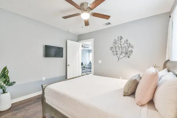 a bedroom with a large bed and a chandelier