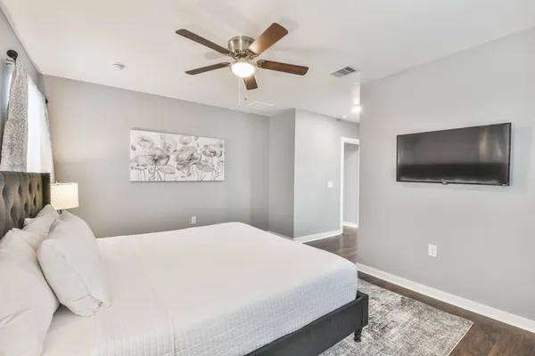 a bedroom with a large bed and a flat screen tv