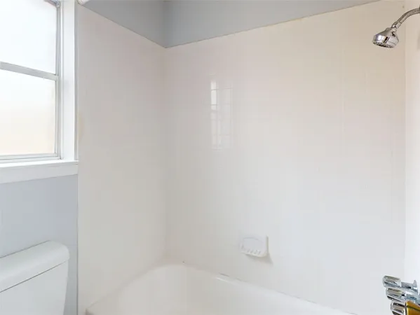 a white bath tub sitting next to a white toilet