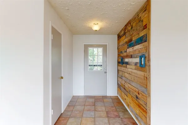 a view of a hallway with wooden floor and a bathroom