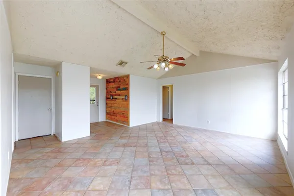 a view of an empty room with a chandelier fan