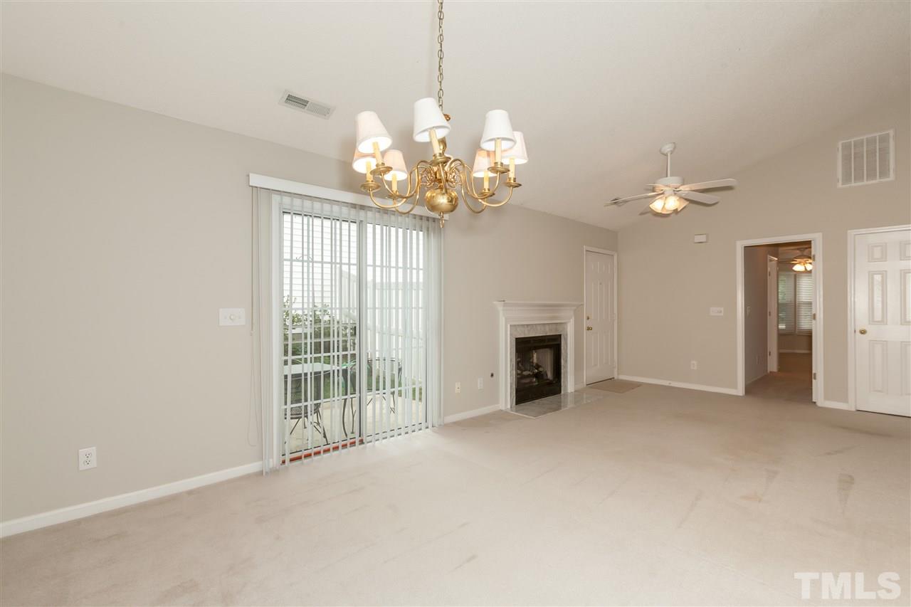 9000 Shallcross Way Raleigh, NC 27617 - Photo 13 of 25 a view of an empty room with a chandelier fan and a fireplace
