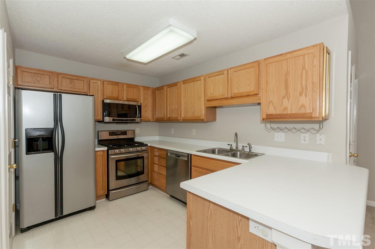 9000 Shallcross Way Raleigh, NC 27617 - Photo 6 of 25 a kitchen with stainless steel appliances granite countertop a refrigerator stove microwave sink and cabinets