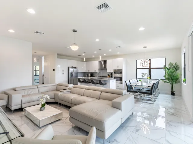 a kitchen with stainless steel appliances kitchen island granite countertop a table and chairs