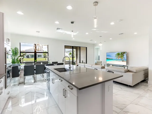 a living room with furniture flat screen tv and a large window