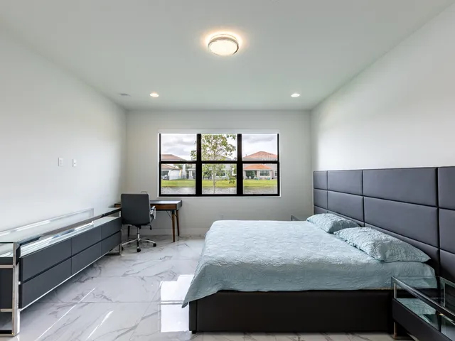 a view of a hallway with wooden floor and a bathroom