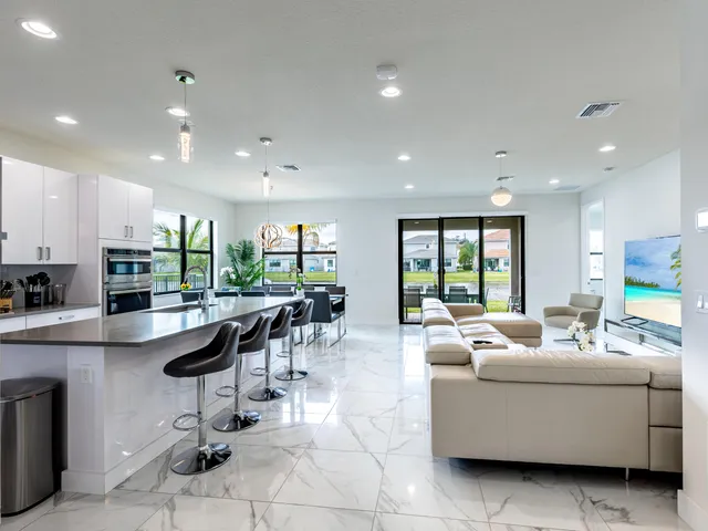 a living room with furniture and a view of kitchen