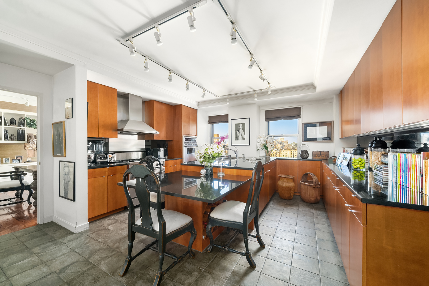 150 East 69th Street, Unit 19N Manhattan, NY 10021 - Photo 5 of 15 a kitchen with stainless steel appliances kitchen island granite countertop a table chairs sink and cabinets