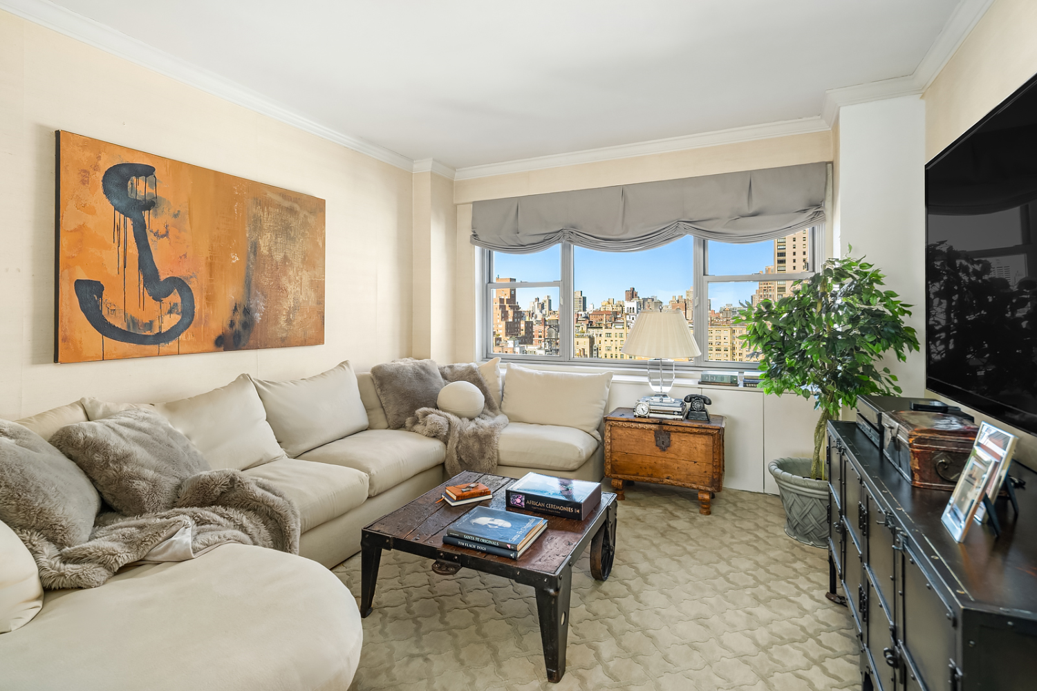 150 East 69th Street, Unit 19N Manhattan, NY 10021 - Photo 9 of 15 a living room with furniture and a flat screen tv