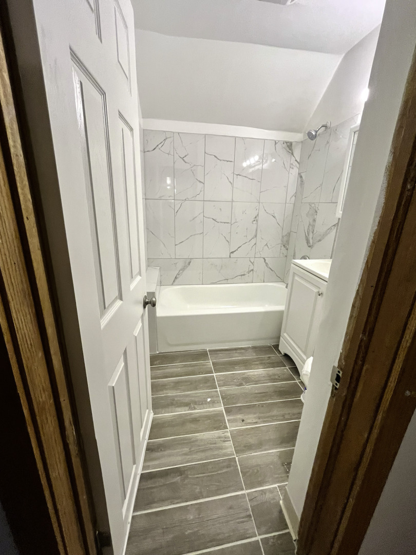 19 South Waller Avenue Chicago, IL 60644 - Photo 4 of 16 a bathroom with a bathtub and shower