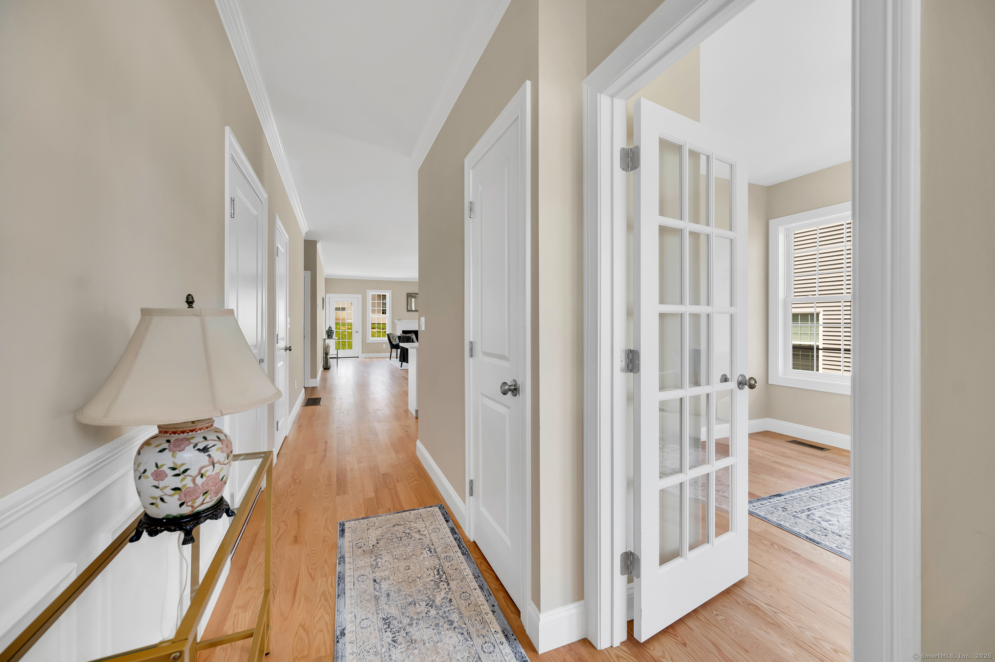 137 Webster Lane, Unit 242 Middletown, CT 06457 - Photo 4 of 17 a view of a hallway to a livingroom with wooden floor and furniture