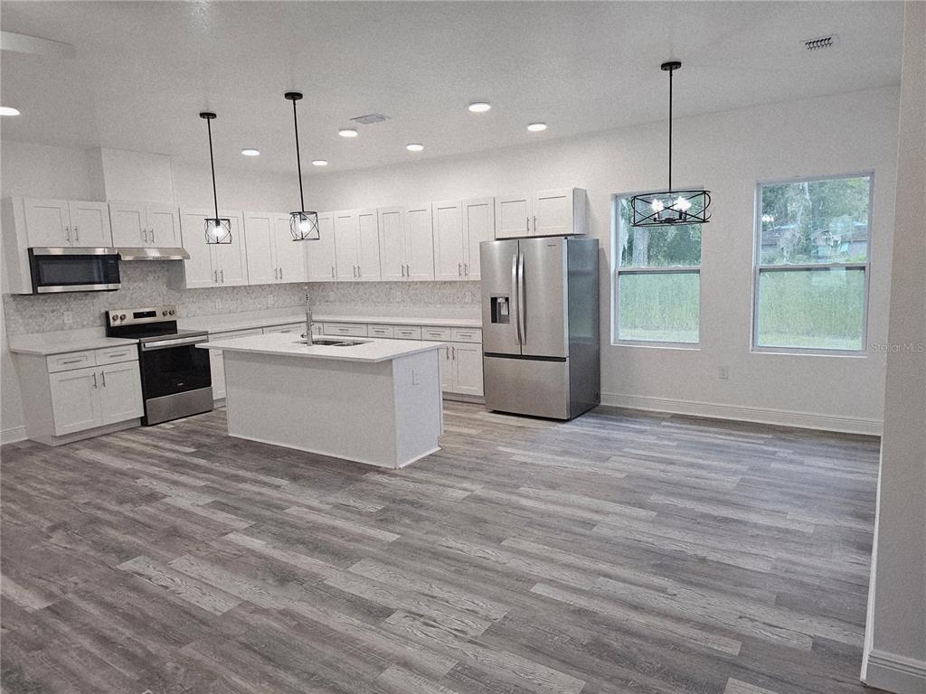 1171 Pine Street Altamonte Springs, FL 32701 - Photo 3 of 14 a kitchen with stainless steel appliances granite countertop a refrigerator and a stove