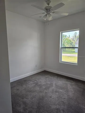 an empty room with a window and a fan