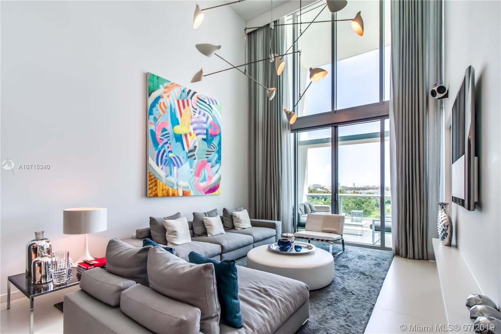 a living room with furniture and a floor to ceiling window