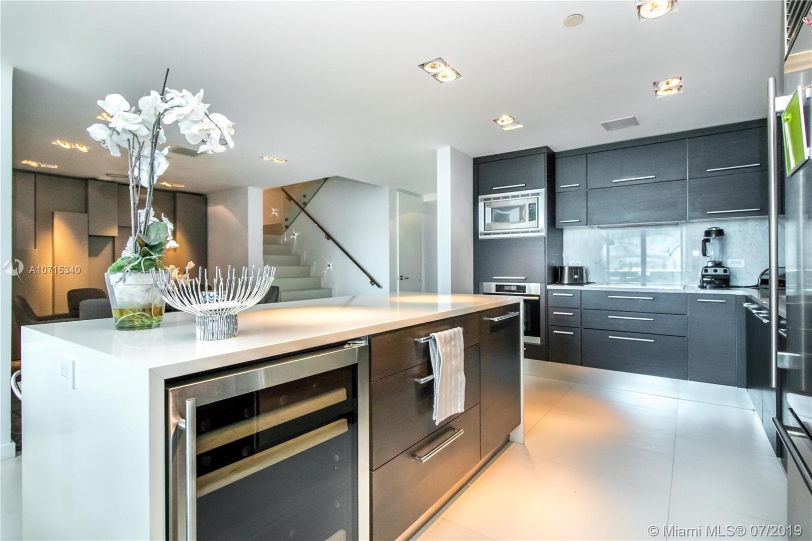 900 Biscayne Boulevard, Unit 705 Miami, FL 33132 - Photo 3 of 43 a kitchen with kitchen island granite countertop a sink cabinets and stainless steel appliances