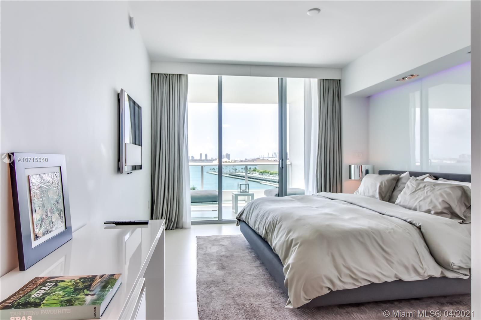 900 Biscayne Boulevard, Unit 705 Miami, FL 33132 - Photo 27 of 43 a bedroom with a bed lamp and a large window