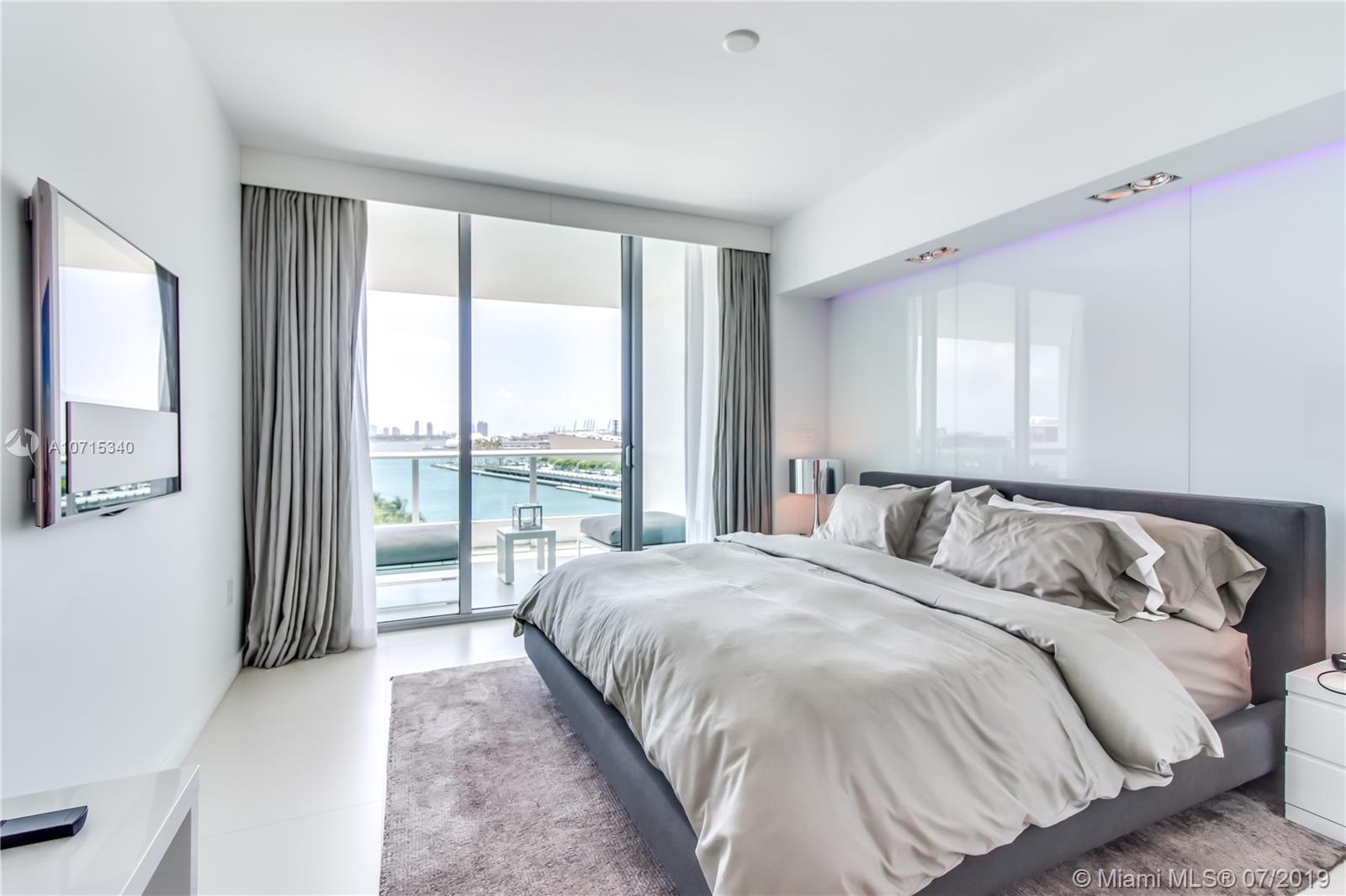 900 Biscayne Boulevard, Unit 705 Miami, FL 33132 - Photo 28 of 43 a bedroom with a large bed and a large window with outer view