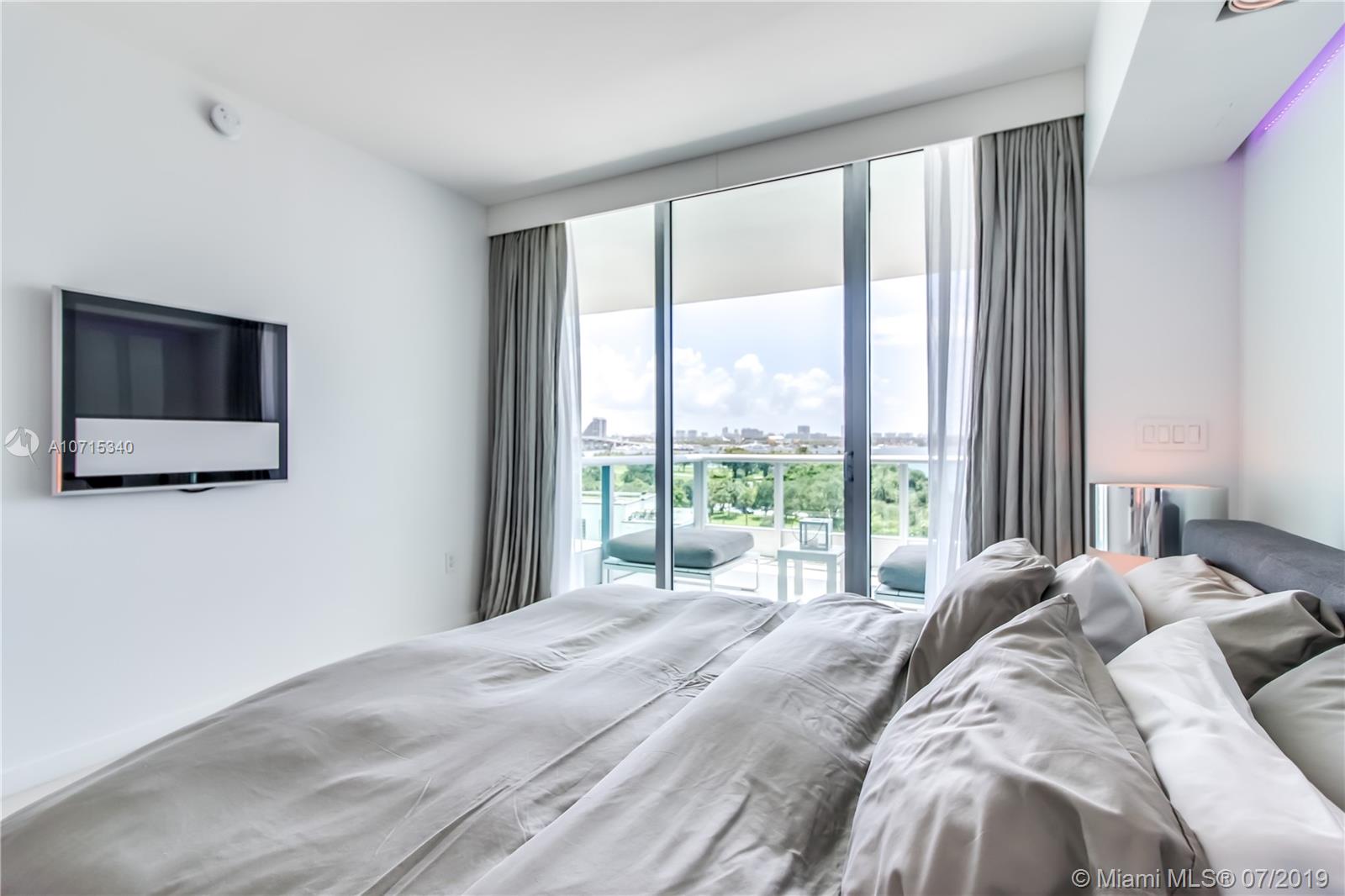 900 Biscayne Boulevard, Unit 705 Miami, FL 33132 - Photo 29 of 43 a bed sitting in a bedroom next to a window