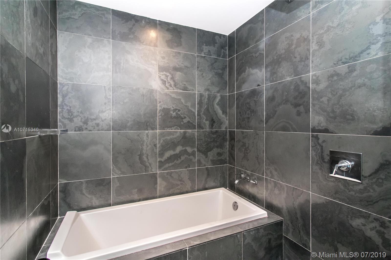 900 Biscayne Boulevard, Unit 705 Miami, FL 33132 - Photo 31 of 43 a bathroom with a bathtub and a shower