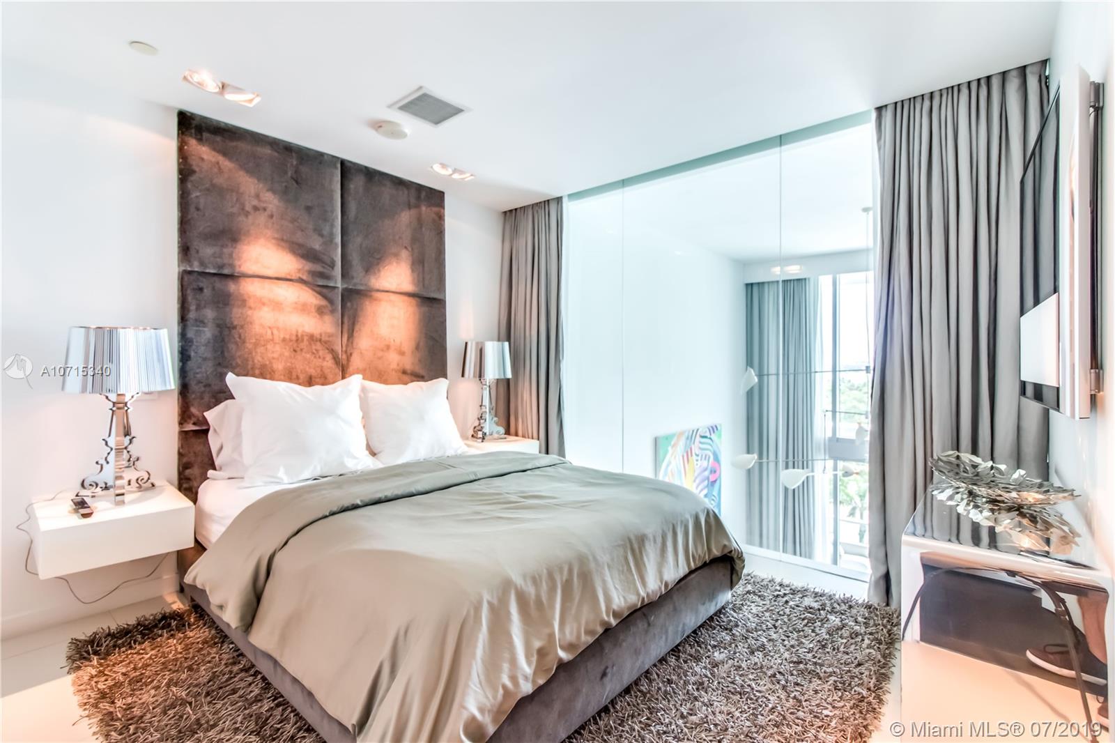 900 Biscayne Boulevard, Unit 705 Miami, FL 33132 - Photo 37 of 43 a bedroom with a bed and a mirror