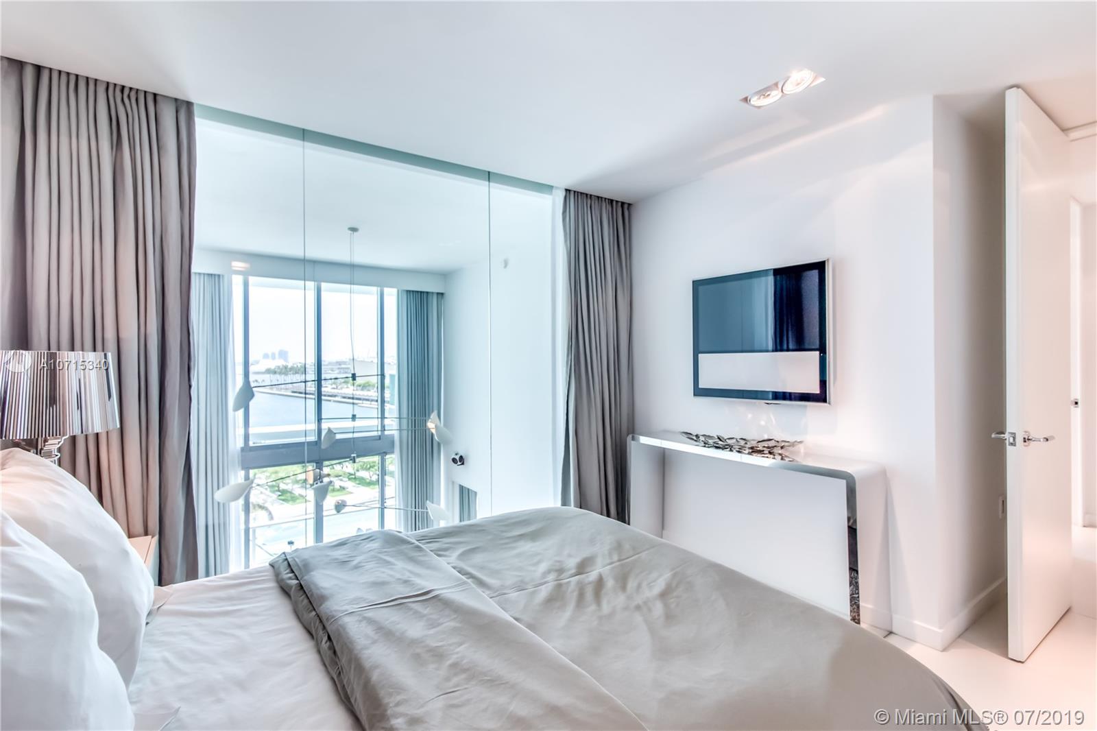 900 Biscayne Boulevard, Unit 705 Miami, FL 33132 - Photo 39 of 43 a bedroom with a bed and a flat screen tv