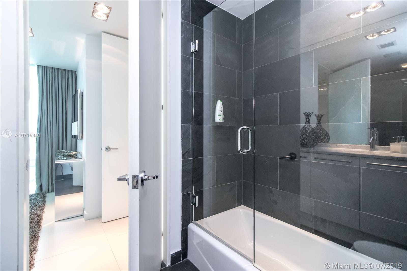 900 Biscayne Boulevard, Unit 705 Miami, FL 33132 - Photo 40 of 43 a bathroom with a bathtub and shower