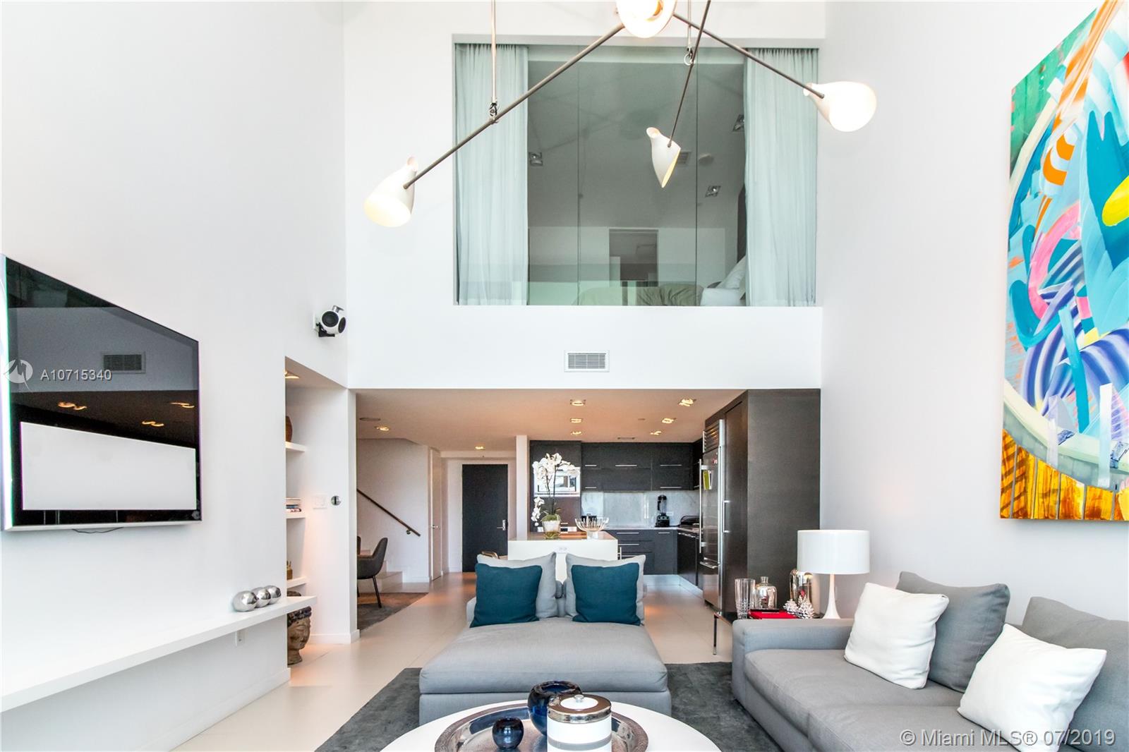 900 Biscayne Boulevard, Unit 705 Miami, FL 33132 - Photo 9 of 43 a living room with furniture and a flat screen tv