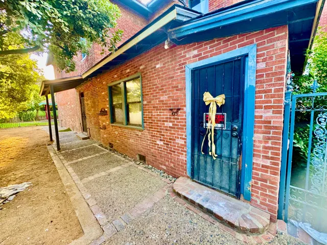 a view of a hallway to a livingroom with wooden floor and stairs