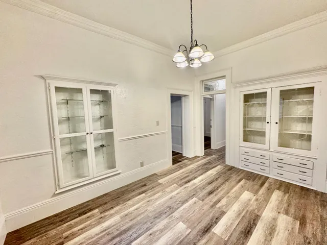 a view of a hallway with wooden floor and staircase