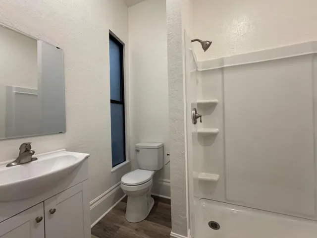 a view of empty room with fireplace and wooden floor