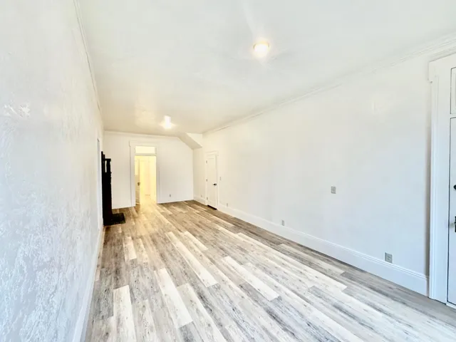 a view of a hallway with wooden floor and staircase