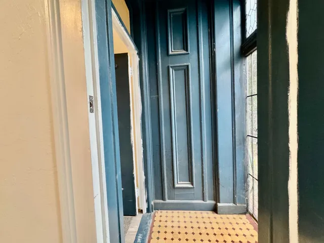 a view of a hallway with wooden floor and stairs