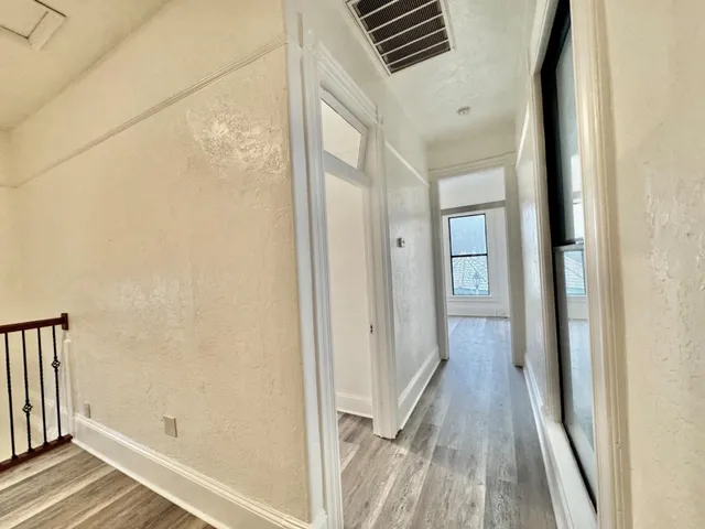 a view of empty room with wooden floor