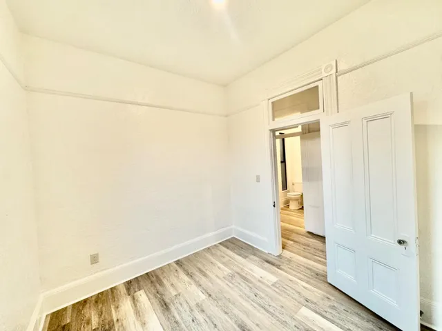 a kitchen with granite countertop a sink cabinets and wooden floor
