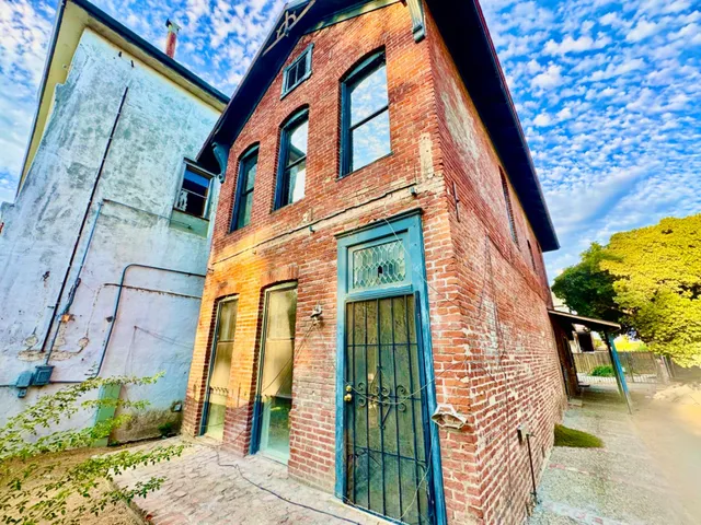 a view of a patio with chairs and a table and chairs under an umbrella