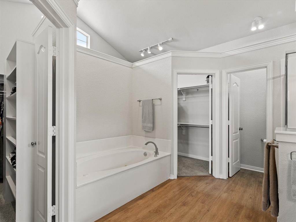 10066 Irish Ridge Forney, TX 75126 - Photo 12 of 39 Bathroom featuring a bath, track lighting, wood finished floors, a spacious closet, and lofted ceiling