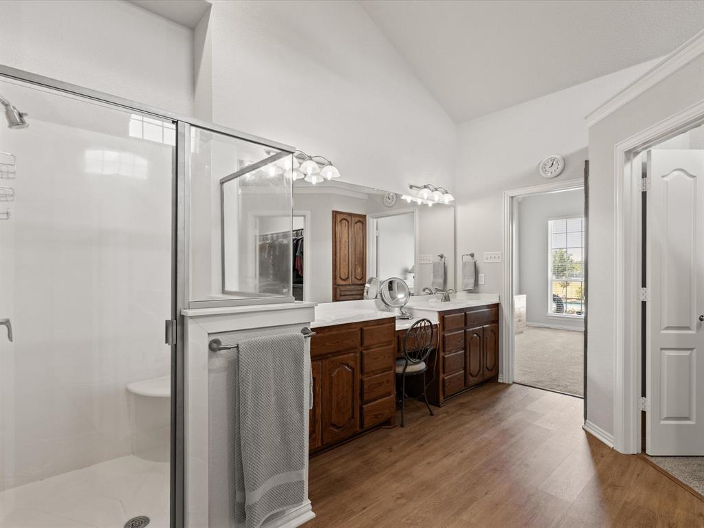 10066 Irish Ridge Forney, TX 75126 - Photo 15 of 39 Bathroom with double vanity, a shower stall, wood finished floors, and high vaulted ceiling