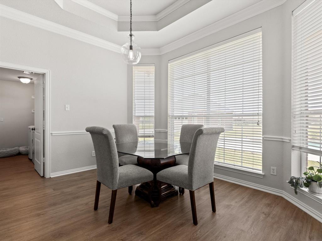 10066 Irish Ridge Forney, TX 75126 - Photo 18 of 39 Dining space featuring healthy amount of natural light, wood finished floors, a tray ceiling, and ornamental molding