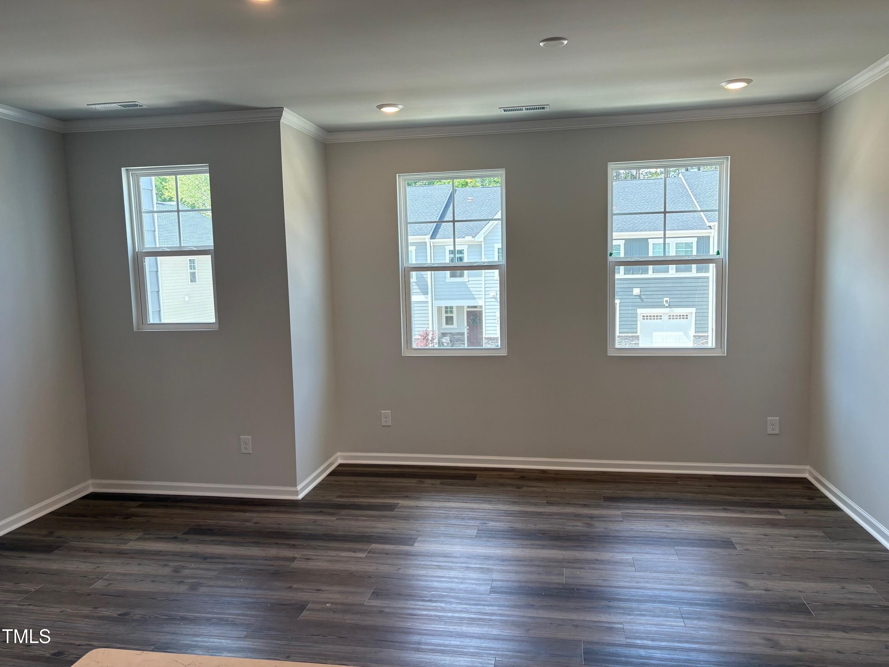 331 Deercroft Drive Apex, NC 27539 - Photo 6 of 21 a view of an empty room with wooden floor and a window