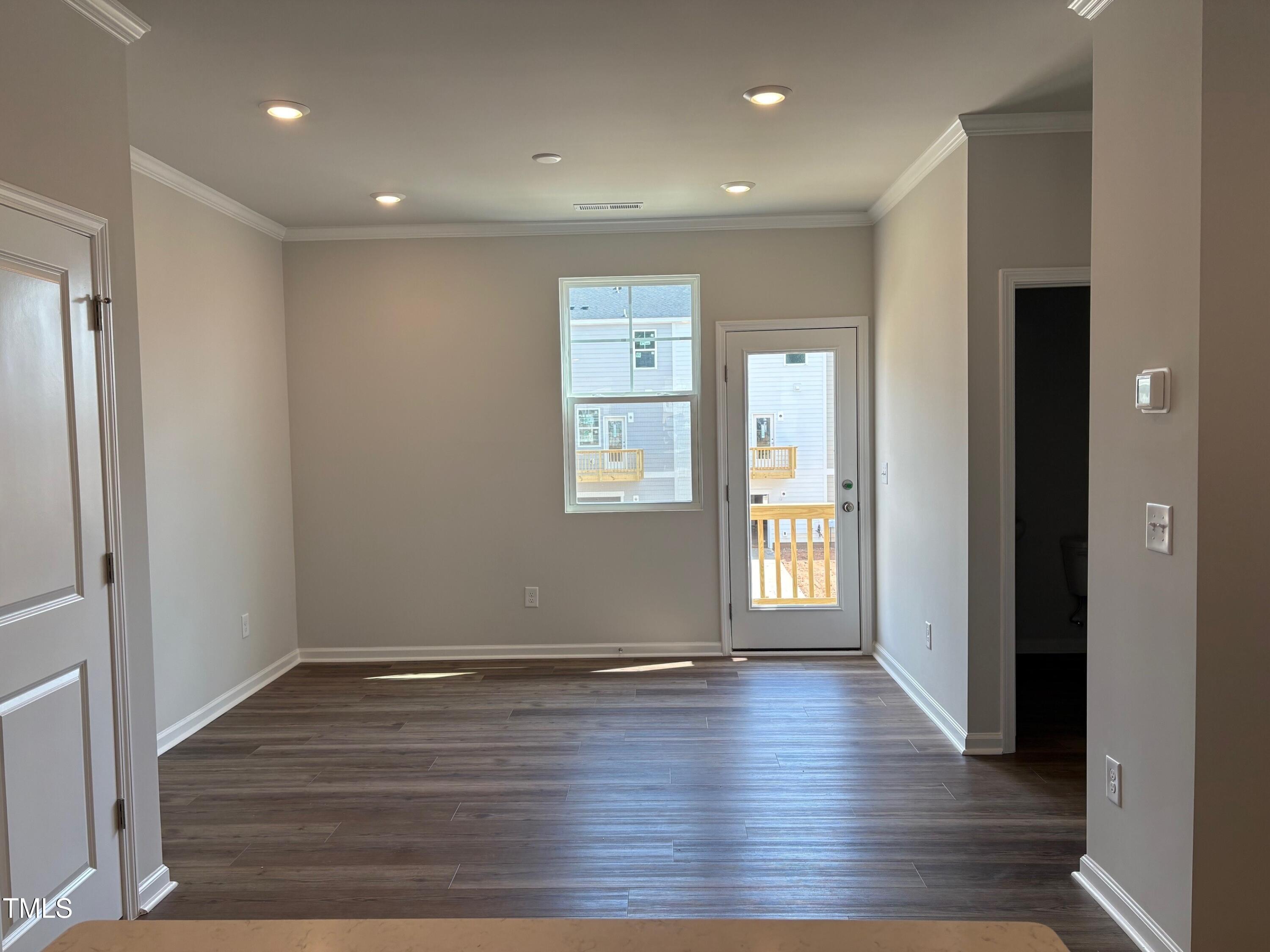 331 Deercroft Drive Apex, NC 27539 - Photo 7 of 21 an empty room with wooden floor and windows