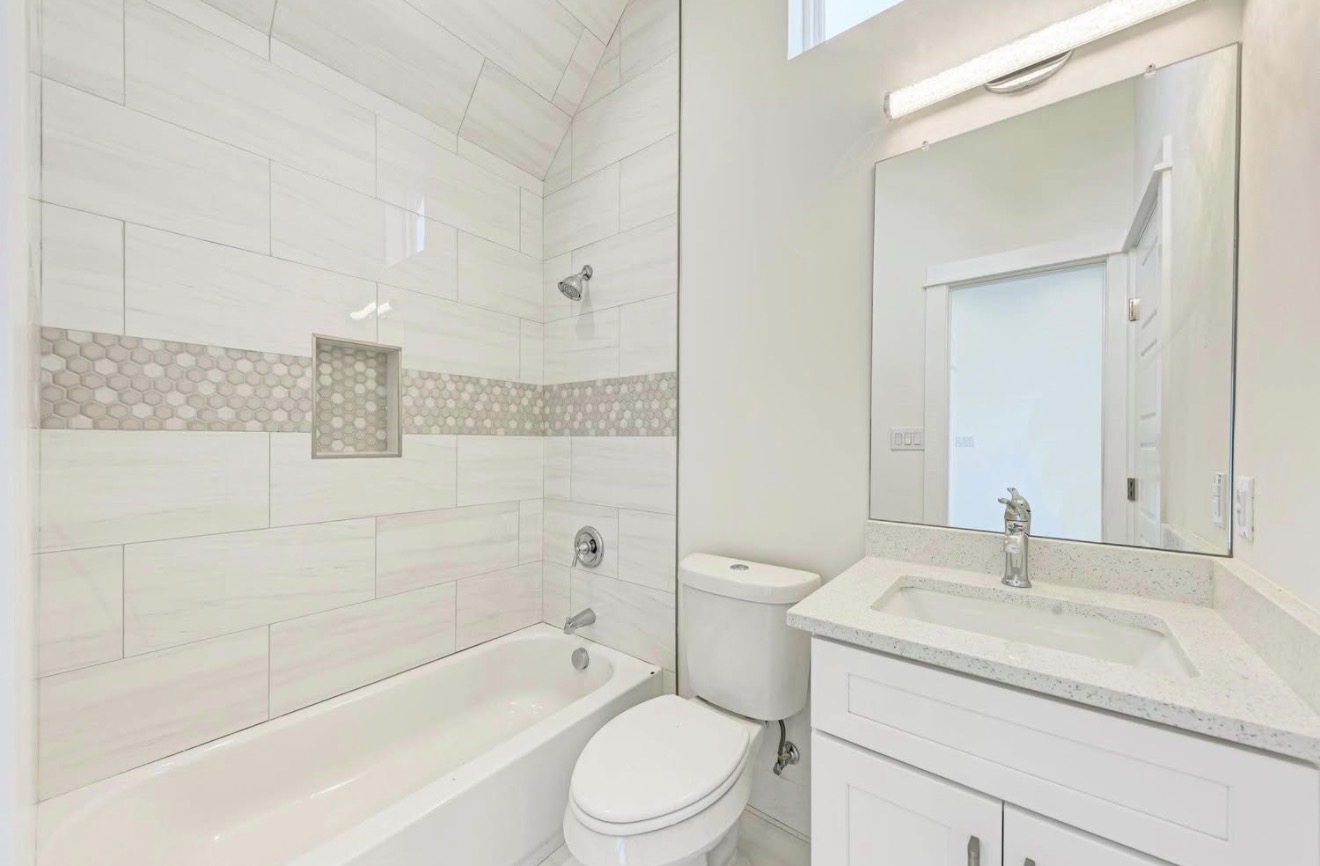 502 Tillery Street, Unit 2 Austin, TX 78702 - Photo 11 of 15 a bathroom with a granite countertop sink a toilet and shower