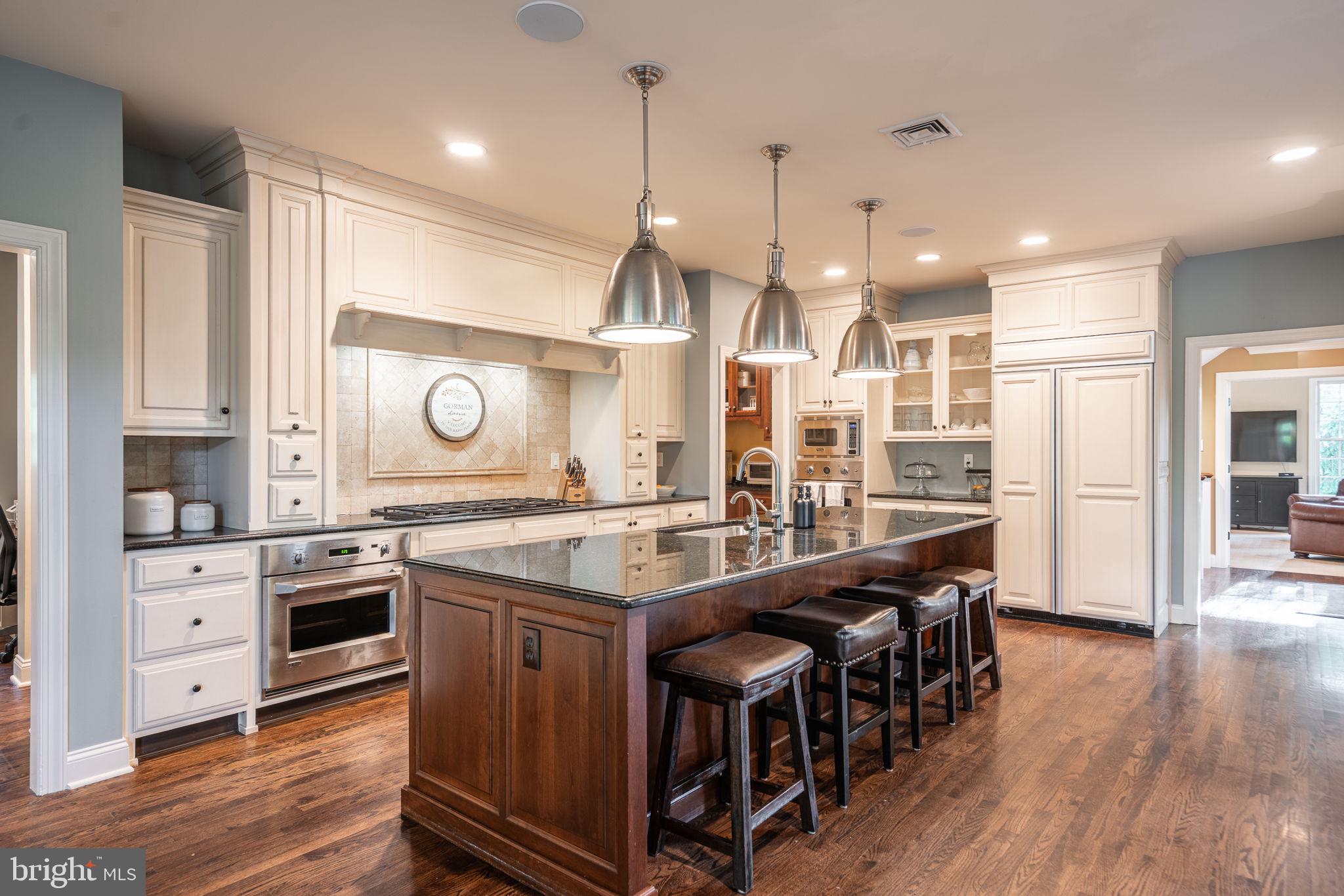 4104 Howell Road Malvern, PA 19355 - Photo 20 of 84 a kitchen with stainless steel appliances kitchen island granite countertop lots of wooden cabinets a sink appliances and wooden floor