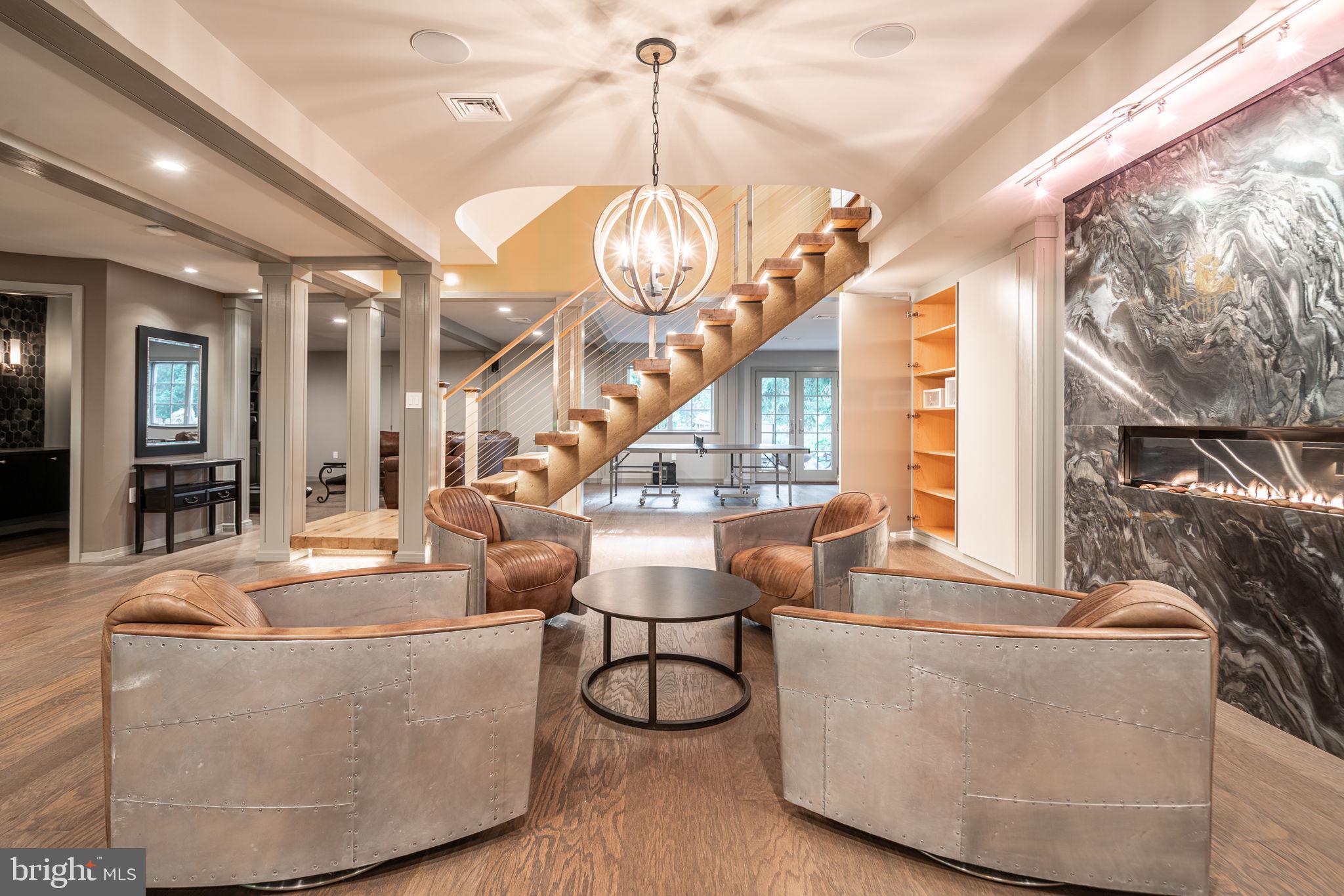 4104 Howell Road Malvern, PA 19355 - Photo 36 of 84 a living room with couches chandelier and a dining table with wooden floor