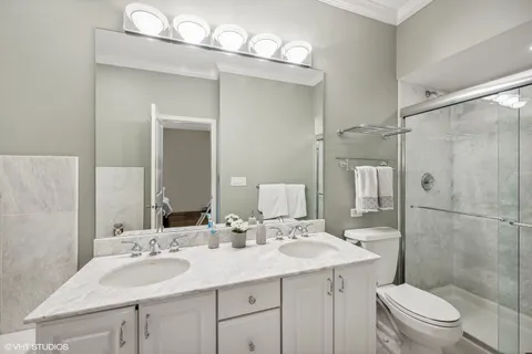 a bathroom with a sink a toilet a mirror and shower